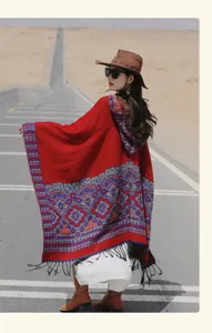 Détail de cape à franges et capuche rouge, châle tricoté ethnique, vêtement chaud pour voyage.