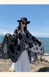 Genaaide gebreide poncho cape sjaal met geometrisch patroon gedragen aan de zeezijde