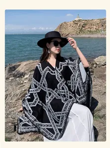 Detailopname van een gebreide poncho in etnische stijl met zwart-witte geometrische patronen