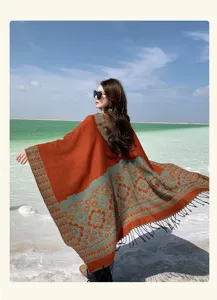 Vue détaillée d'une cape à capuche élégante avec motif floral et franges pour voyages en plein air.