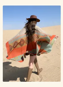 Vista trasera de mujer con capa de viaje geométrica naranja gruesa y cálida de estilo bohemio.