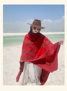 Detailopname van een rode etnische poncho met geometrisch patroon op een zonnig wit strand