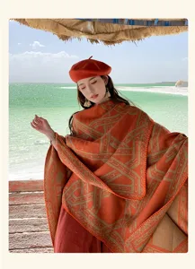 Bohemian terracotta gebreide poncho met geometrische patronen voor winterse reisfotografie