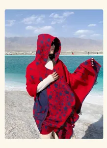 Scialle mantella con cappuccio rosso e motivo stellato, capo caldo per la fotografia.