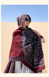 Vue détaillée d'un poncho cape à capuche motif ethnique imitation cachemire frangée au désert.