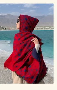 Dettaglio mantella con cappuccio da viaggio, motivo stelle rosse e blu con frange.
