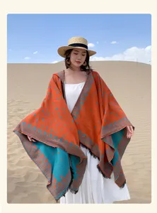 Kapuzenponcho im Ethno-Stil mit Sternenmustern, bunten Kontrastfarben und Quasten für den Urlaub.