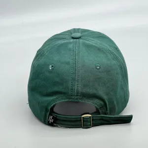 Vue détaillée de la casquette verte montrant la sangle réglable et la boucle.