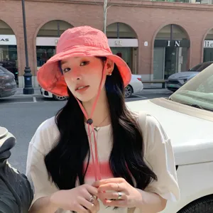 Vue détail chapeau bob rose en extérieur, chapeau de soleil élégant avec lanière.