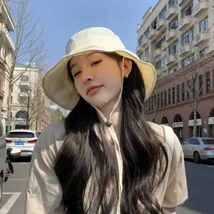 Scène de rue extérieure détaillée avec un chapeau bob beige léger et cordon réglable.