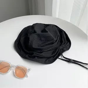 Vue détaillée du chapeau bob noir d'été avec cordon de serrage réglable et tissu à séchage rapide.