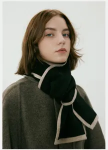 Dettaglio della sciarpa in maglia bicolore da donna, accessorio invernale morbido e caldo.