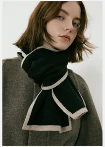 Primo piano dettagliato della sciarpa invernale in maglia bicolore morbida ed elegante.