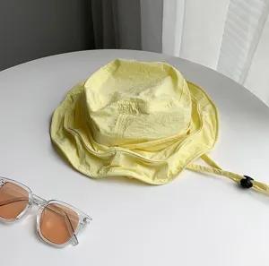 Vue detaillee dun chapeau de pecheur d ete leger en jaune avec texture textile a sechage rapide.