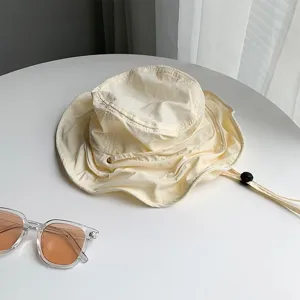 Gros plan sur le bob d'été léger avec cordon de serrage ajustable et lunettes de soleil.