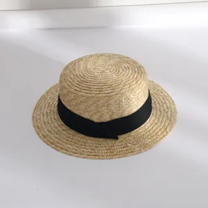 Nahaufnahme der feinen Strohflechttextur und des eleganten schwarzen Bandes am Sommerhut.