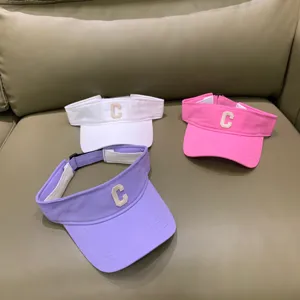 Detailansicht stilvoller, leerer Sonnenhüte in Weiß, Rosa und Lila mit schicker Stickerei.
