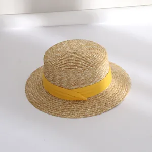Detailaufnahme des flachen Damen Strohhuts im Sommer mit stylischem gelbem Band.
