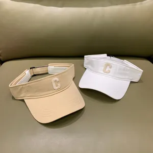 Detailansicht von sommerlichen leeren Sonnenblenden in Beige und Weiß mit Buchstabenstickerei.