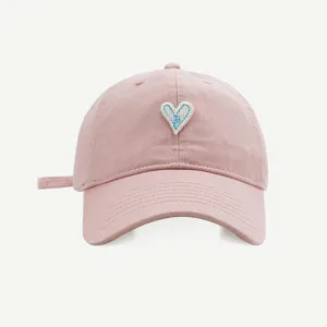 Nahaufnahme der rosa Baseballkappe mit einem niedlichen gestickten blauen Herz-Aufnäher.