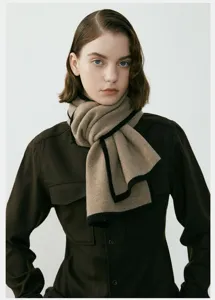 Dettaglio di sciarpa invernale in maglia bicolore, morbida texture e bordo elegante.