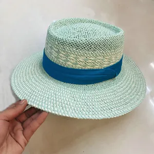 Vue de detail d'un tres elegant chapeau de paille femme ruban bleu plat vacances d'ete.