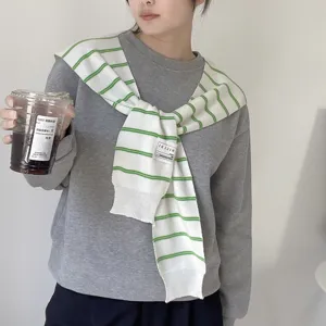 Striped knitted shawl tied over grey sweatshirt, fashion casual clothing for women.