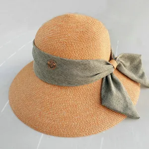 Vue détail chapeau de paille d'été, élégant nœud ruban gris, protection solaire à large bord.