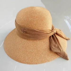 Chapeau de paille élégant pour femmes avec nœud ruban et logo métallique chic pour la plage.