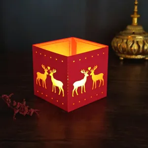 Close-up detail of the red laser-cut paper candle holder featuring cute deer patterns.