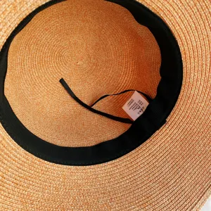 Vue intérieure détaillée du chapeau de paille d'été montrant la texture et l'étiquette.