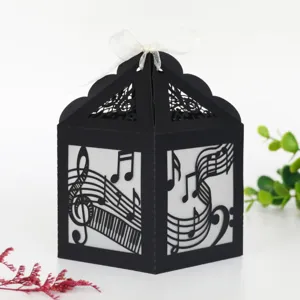 Vue de détail rapprochée de la boîte cadeau en papier noir avec notes de musique et ruban.
