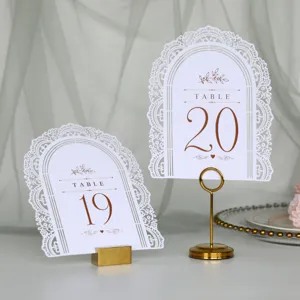 Segnatavolo da matrimonio bianchi con supporti dorati, design ad arco intagliato al laser.