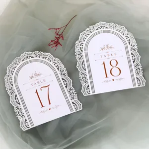 Segnatavolo da matrimonio bianchi tagliati al laser con elegante design in pizzo traforato.