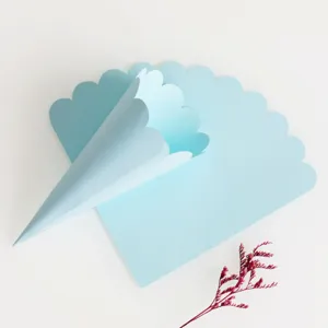 Confetti cone detail shot showing scalloped edge blue paper card design for wedding party DIY use.