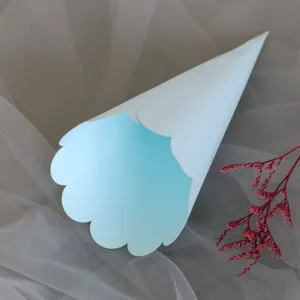 Wedding confetti paper cone detail view, light blue scalloped edge cone for party celebration.