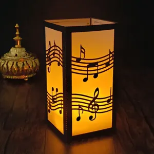 Laser cut paper night light detail showing musical notes pattern and warm internal glow.