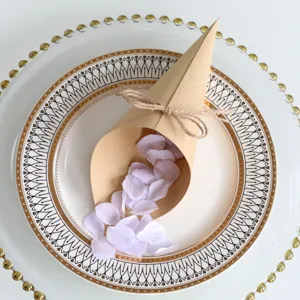 Kraft paper confetti cone with twine bow and purple rose petals for wedding party decor.