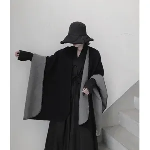 Vista dettagliata della mantella reversibile nera e grigia, morbida e di stile.