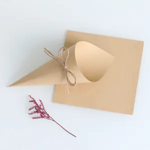 Kraft paper confetti cone detail, rustic wedding party DIY accessory with twine and dried flower.