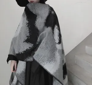 Vista dettagliata di un poncho effetto cashmere nero e grigio mantella calda sciarpa.