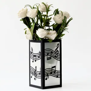 Black paper hollow musical note vase with white artificial rose flower bouquet for decor