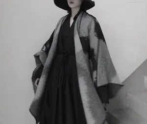 Vista dettagliata della mantella scialle effetto cashmere tie-dye nero e grigio stile invernale.