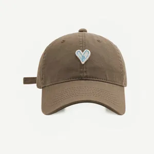 Braune Baumwoll-Baseballkappe Detailansicht mit dem süßen weiß-blauen Herz-Bestickungs-Patch.