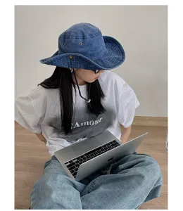 Vintage washed blue denim bucket hat detail view, wide brim outdoor sun protection hat styling.