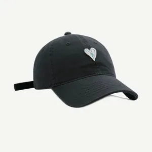Schicke schwarze Baumwollkappe mit aufgesticktem weißem Herz für modebewusste Damen.