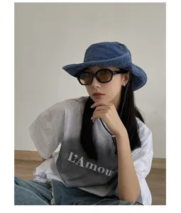Detail view of stylish blue denim bucket hat with chin strap, perfect for outdoor sun protection.