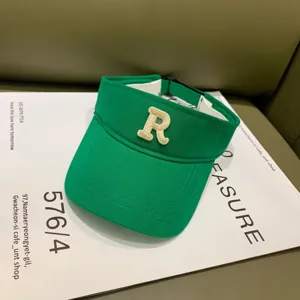 Grüne sommerliche Sonnenblende Kappe im Detail, mit auffälligem gesticktem Buchstaben R.