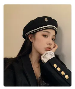 Primo piano di un berretto nero con perle e strass indossato da una modella, elegante.