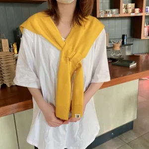 Detailed view of women solid color knitted shawl crossover winter warm scarf stylish outerwear.